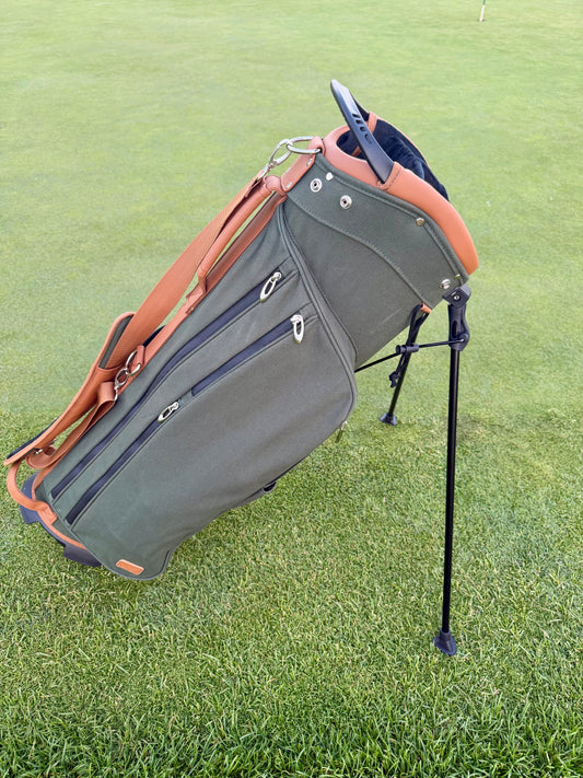Green golf bag with brown accents on a grassy background