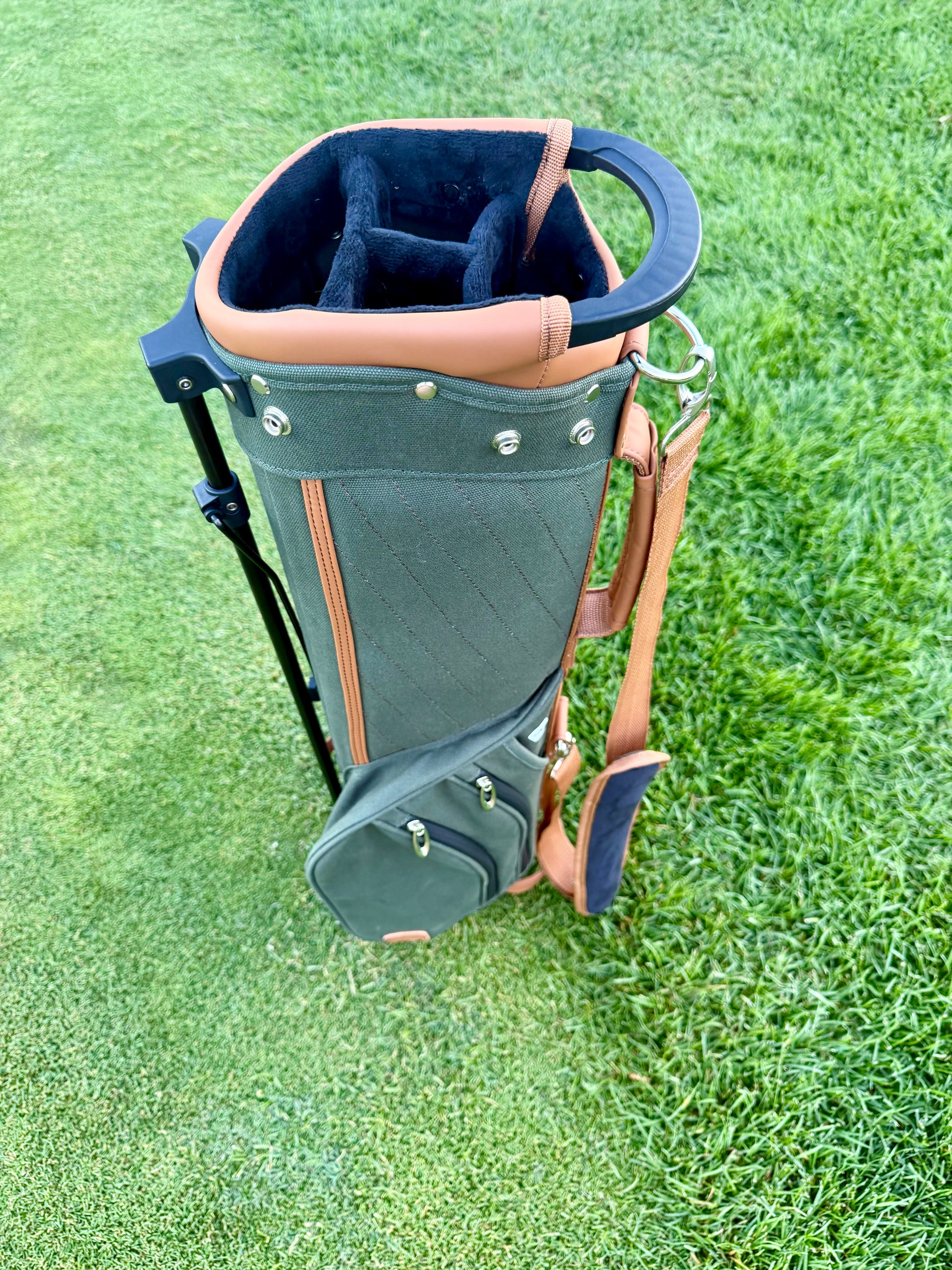 Golf bag with a black and brown design on a grassy background